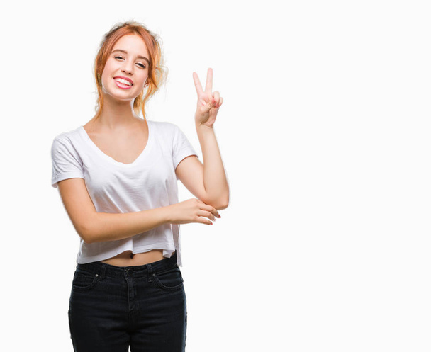 Young beautiful woman over isolated background smiling with happy face winking at the camera doing victory sign. Number two. - Photo, Image