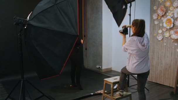 Mujer joven modelo teniendo una sesión de fotos en el estudio. Disparos entre bastidores
 - Metraje, vídeo