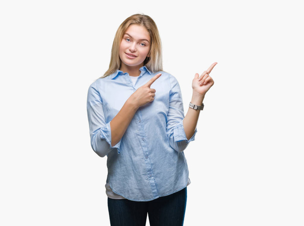 Young caucasian business woman over isolated background smiling and looking at the camera pointing with two hands and fingers to the side. - Foto, imagen