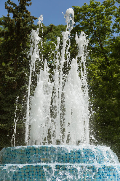 Fontaine de la ville. Fontaine dans le parc de la ville par une chaude journée d'été. Flux d'eau, gouttes et éclaboussures lumineuses d'eau dans la belle fontaine de la ville. Flux lumineux d'eau pétillante dans la fontaine de la ville dans la journée
 - Photo, image