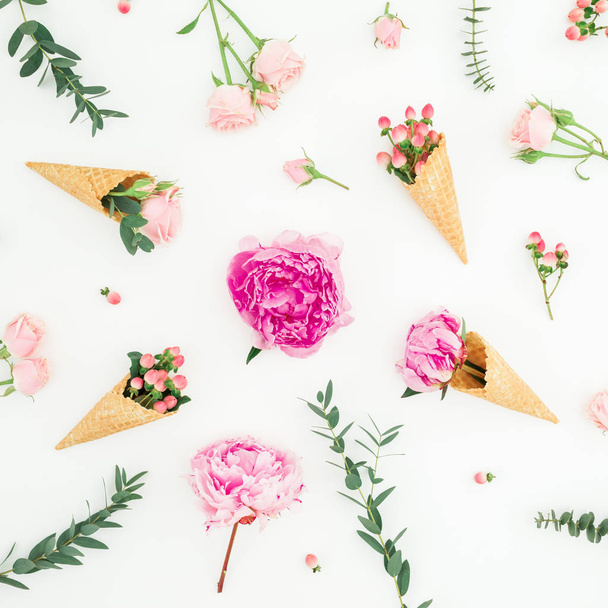 Floral pattern of pink peonies, roses petals, eucalyptus and waffle cones on white background. Flat lay, top view - Zdjęcie, obraz