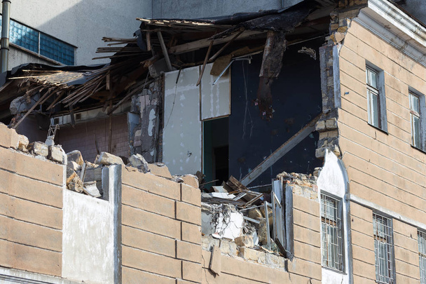 Ένα εγκαταλελειμμένο σπίτι καταρρέει σε μια φτωχή γειτονιά. Το σπίτι έχει καταστραφεί. Ρωγμές στον τοίχο του σπιτιού. Καταστροφή των παλιών σπιτιών, σεισμούς, οικονομική κρίση, εγκαταλελειμμένα σπίτια. Σπασμένα ακατάλληλα σπίτι - Φωτογραφία, εικόνα