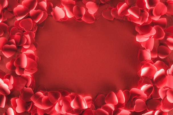top view of decorative heart shaped petals on red background, valentines day concept - Photo, image