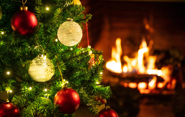 Kersttijd, warme thuis. Kerstboom dicht omhoog onscherpe achtergrond voor brandende open haard, kopieer op ruimte - Foto, afbeelding