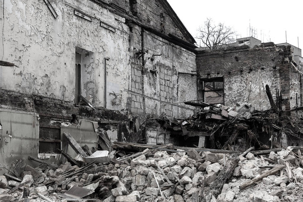 In einem Armenviertel stürzt ein verlassenes Haus ein. Das Haus ist zerstört. Risse in der Hauswand. Zerstörung alter Häuser, Erdbeben, Wirtschaftskrise, verlassene Häuser. Untaugliches Haus kaputt - Foto, Bild