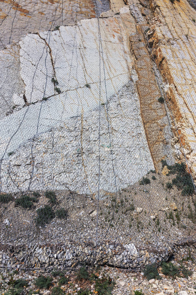 Ενίσχυση των επικίνδυνων ορεινές πλαγιές στην περιοχή της οδού με ειδικό μεταλλικό πλέγμα. Προστασία του δρόμου από βουνό slough, rockfall με μεταλλικό σωρευτικοί αναχαίτησης καθαρή φράχτες - Φωτογραφία, εικόνα
