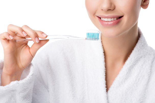 cropped view of woman in white bathrobe holding toothbrush isolated on white - Photo, image