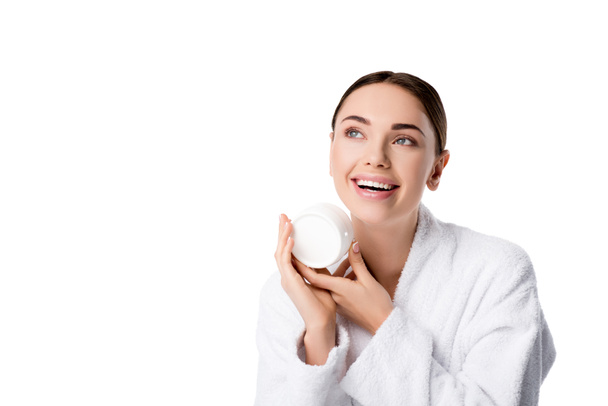 весела жінка в халаті тримає крем для обличчя ізольовано на білому
 - Фото, зображення