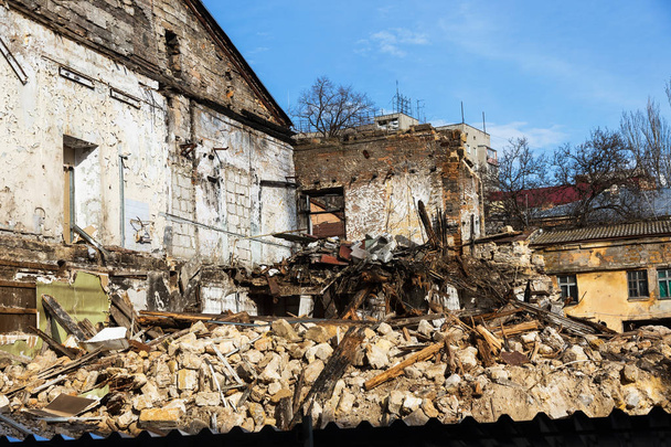 Een verlaten huis stort in een arme buurt. Het huis wordt vernietigd. Scheuren in de muur van huis. Vernietiging van oude huizen, aardbevingen, economische crisis, verlaten huizen. Gebroken ongeschikt huis - Foto, afbeelding