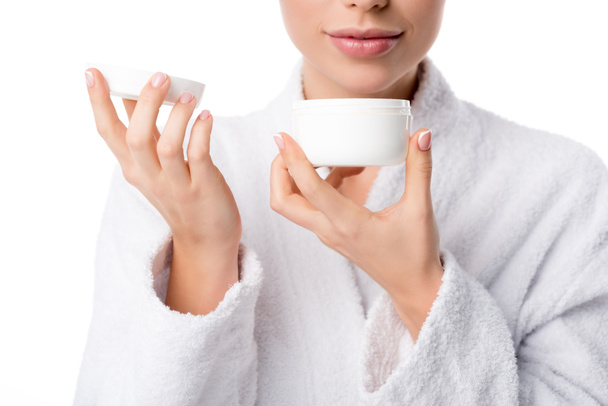 cropped view of woman in bathrobe smelling aroma of face cream isolated on white - Photo, Image