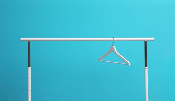 Wardrobe rack with hanger on color background - Φωτογραφία, εικόνα