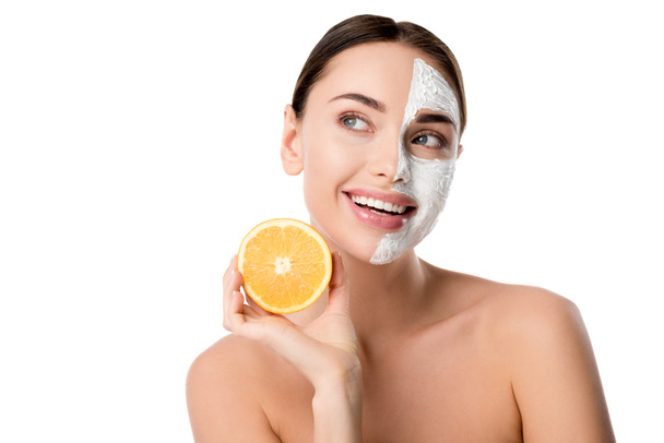 beautiful happy woman with facial skin care mask holding orange isolated on white - Foto, Imagem