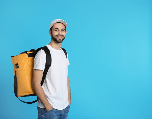 Young courier with thermo bag on color background, space for text. Food delivery service - Photo, image
