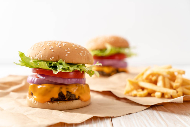 fresh tasty beef burger with cheese and french fries on wood background - Φωτογραφία, εικόνα