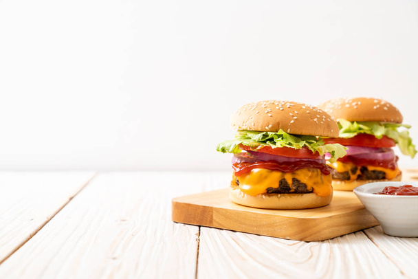 fresh tasty beef burger with cheese and ketchup on wood background - Фото, изображение