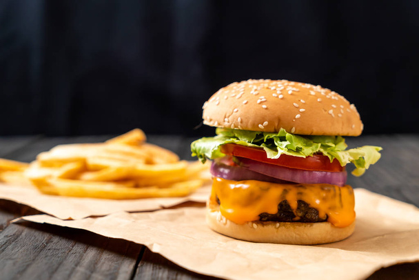 fresh tasty beef burger with cheese and french fries on wood background - Fotoğraf, Görsel