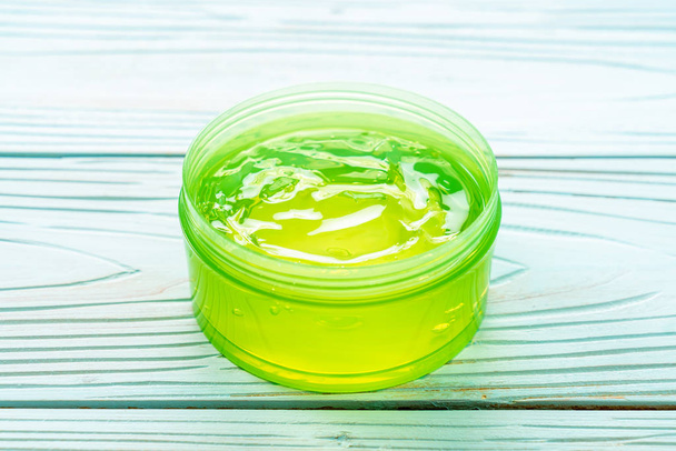 aloe vera gel with aloe sliced on wood background - Foto, afbeelding