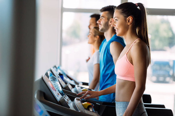 Picture of sporty people running on treadmill in gym - Foto, immagini