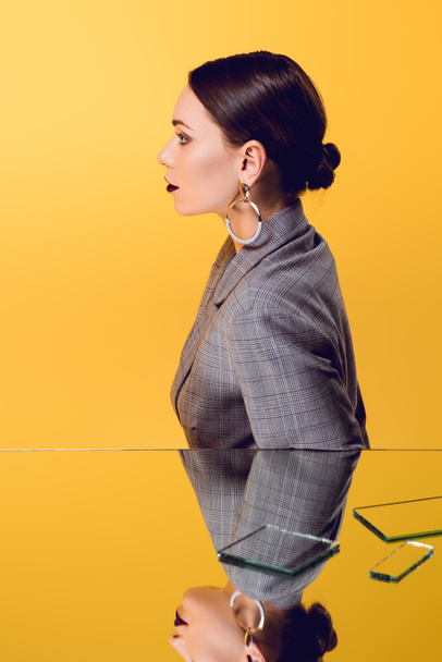 beautiful glamorous woman in formal wear with mirror reflection isolated on yellow - Фото, зображення