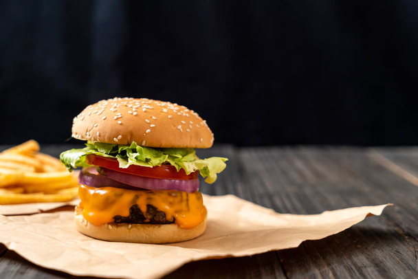 fresh tasty beef burger with cheese and french fries on wood background - Valokuva, kuva