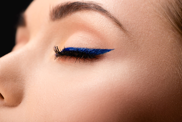 cropped view of closed female eye with blue eyeliner and perfect skin - Foto, immagini