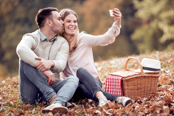 Ευτυχισμένο ζευγάρι κάμπινγκ στη φύση, λαμβάνοντας μια selfie φωτογραφία. - Φωτογραφία, εικόνα