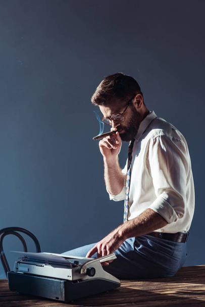 handsome man smoking and using typewriter - Fotografie, Obrázek