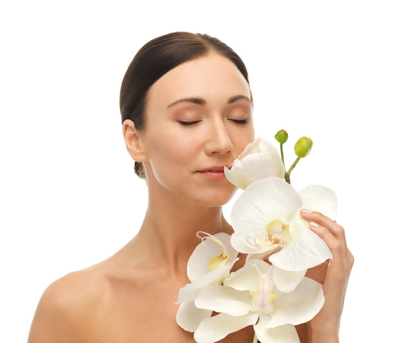 Mulher cheirando flor de orquídea branca
 - Foto, Imagem