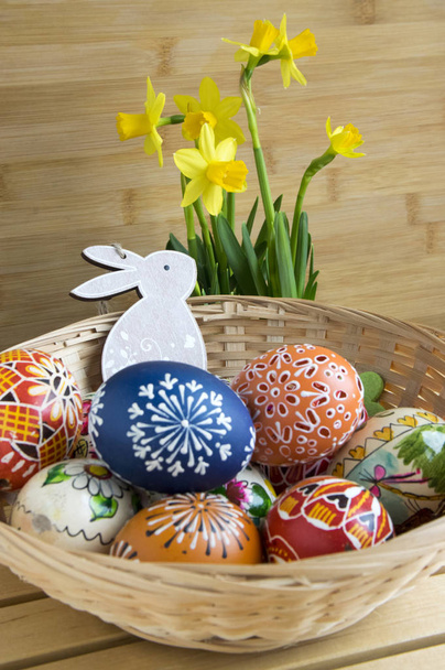 Domácí ručně dělané Česká malovaná vejce a dřevěný zajíček, žlutý Narcis žlutý květ, dřevěné pozadí, Velikonoční dekorace na stůl - Fotografie, Obrázek