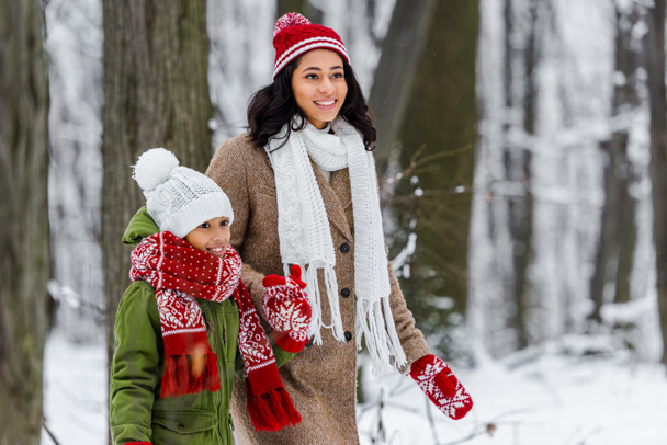 beautiful african american girl and preteen child walking in winter park - Photo, Image