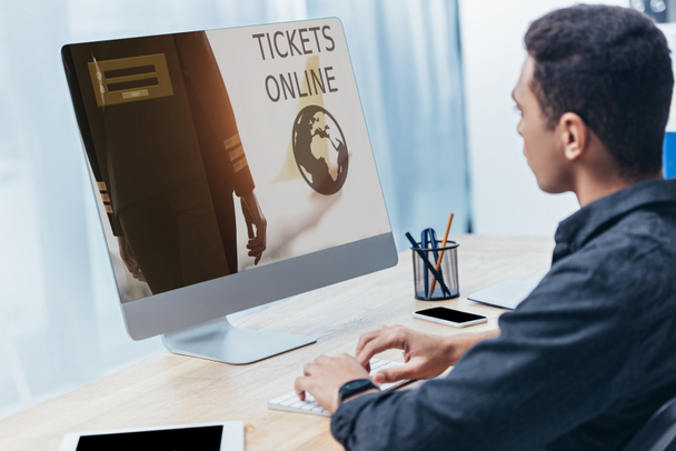 jonge zakenman desktopcomputer met tickets online website op scherm in kantoor - Foto, afbeelding