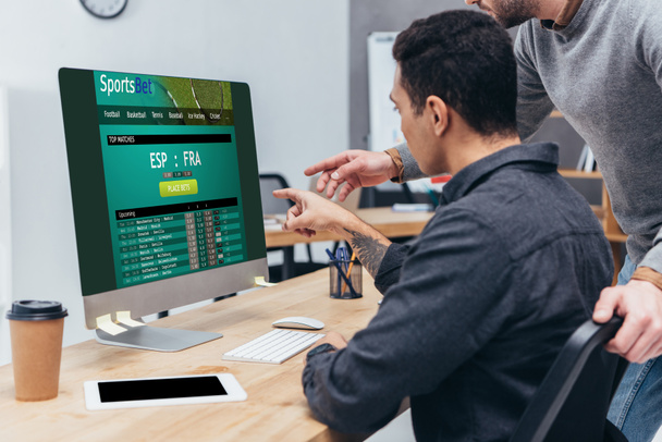 オフィスで画面に web サイトを賭けるスポーツでデスクトップ コンピューターを使用してビジネス同僚のショットをトリミング  - 写真・画像