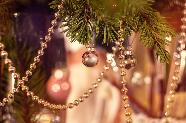 Weihnachtskugeln und Girlanden auf Tannenzweigen, Funkeln auf Bokeh-Hintergrund. Weihnachten und Neujahr Hintergrund. - Foto, Bild