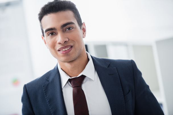 portrait of handsome young mixed race businessman smiling at camera - Фото, зображення