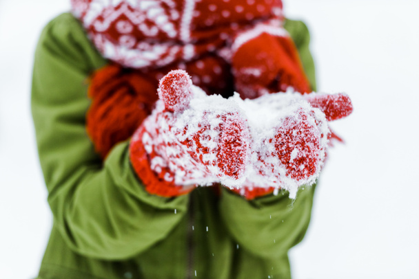 niño con guantes rojos soplando nieve blanca
  - Foto, imagen
