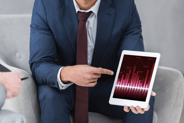 cropped shot of businessman in formal wear pointing with finger at digital tablet with business charts  - Фото, изображение