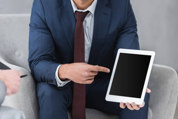 cropped shot of businessman in formal wear pointing with finger at digital tablet with blank screen - Zdjęcie, obraz