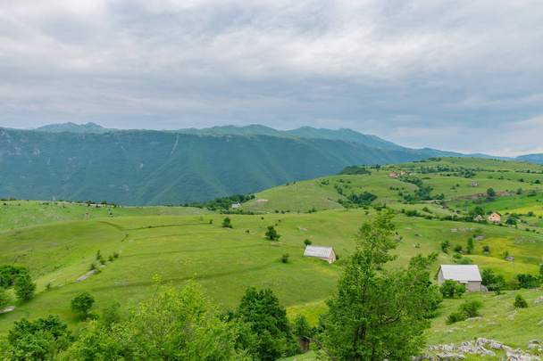 pequena aldeia localizada entre colinas verdes
 - Foto, Imagem