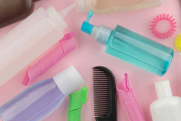 Különböző hajápolási termékek és a haj kiegészítők, a világos rózsaszín háttér. hajápolási kozmetikumok. szemközti nézet hely a szöveg. háttér - Fotó, kép