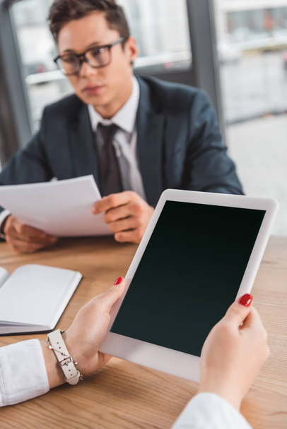 recortado de mujer de negocios utilizando tableta digital con pantalla en blanco en el lugar de trabajo
 - Foto, imagen