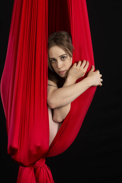 Petite atlético morena acrobata em um casulo de seda vermelha
 - Foto, Imagem