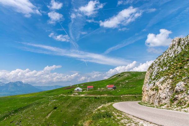 Панорамный вид на живописную деревню среди лугов на высоких горах
 - Фото, изображение