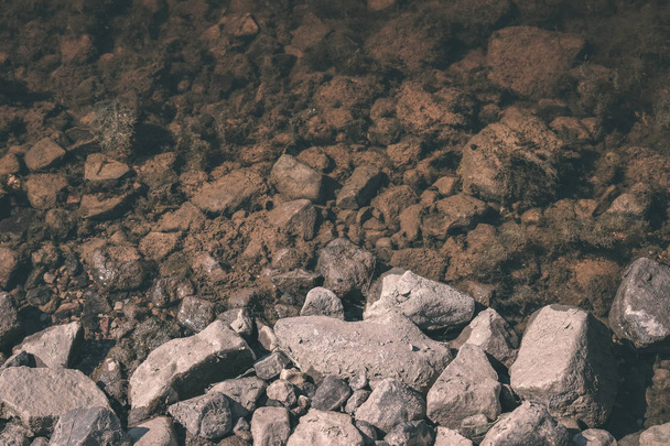 close up view of stones in river water - Foto, afbeelding
