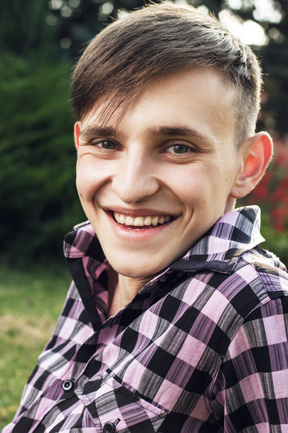 Portrait of happy young man in park - Foto, imagen
