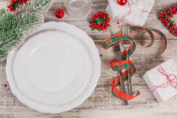 Winter place setting with Christmas and New Year decorations on white wooden table. Festive table setting for Christmas dinner. - Photo, Image