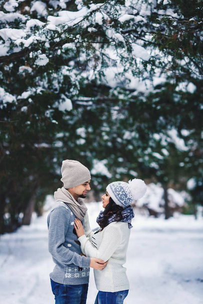 mies ja tyttö villapaidoissa halailemassa puistossa talvella. talvella kävellä, levätä
. - Valokuva, kuva