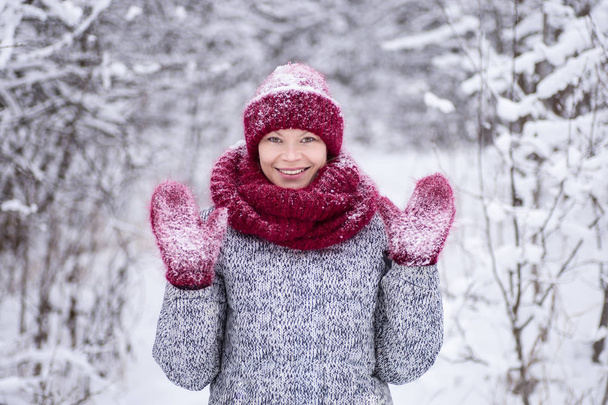 Girl in the red hat and a scarf having fun in the winter park - Foto, Bild