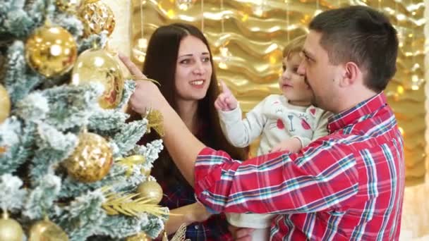 happy family with little daughter has fun near decorated Christmas tree at home - Footage, Video