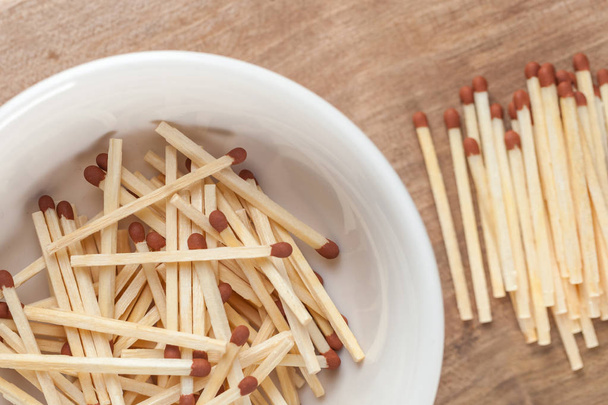 match sticks in the ceramic bowl on the wooden table. - Photo, Image
