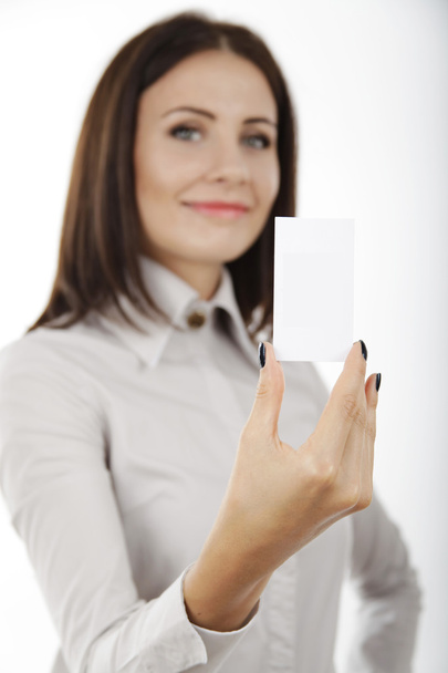 Hermosa mujer de negocios sosteniendo una tarjeta en blanco en su mano
. - Foto, imagen